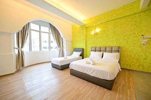 a bedroom with two beds and a window at First Star Homestay in Kluang