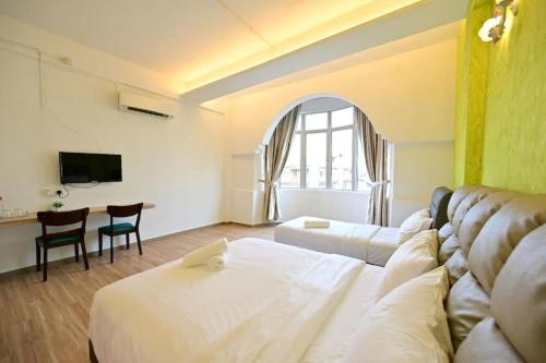 a room with a couch and a table and a tv at First Star Homestay in Kluang
