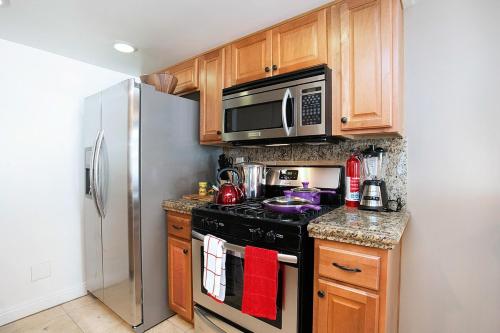 a kitchen with a stove and a stainless steel refrigerator at Costa Mesa -Newport- Patio - Free Parking-CM-2 in Costa Mesa