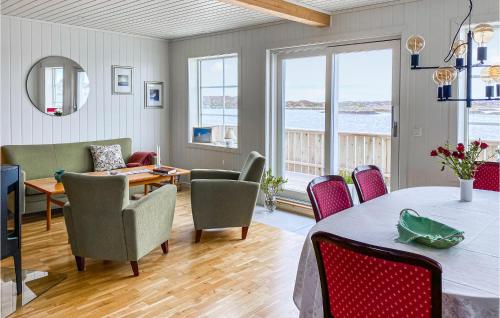 a living room with a dining room table and chairs at Beach Front Home In Smøla With Kitchen in Smøla