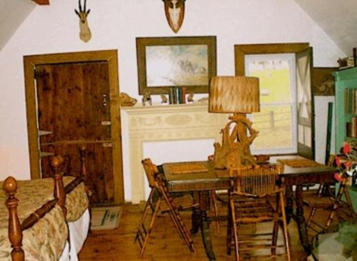 a bedroom with a desk with a lamp and a bed at Whistler's Inn in Lenox