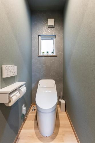 a bathroom with a white toilet and a window at The Comfy Sapporo in Ōdōri