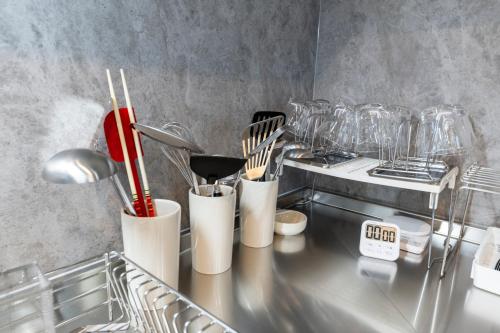 a kitchen counter with utensils and utensils at The Comfy Sapporo in Ōdōri