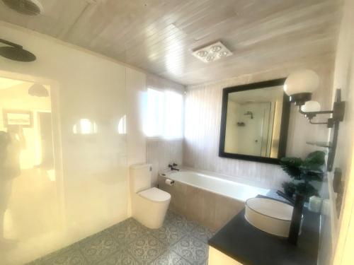 a bathroom with a tub and a toilet and a mirror at The Jazz B&B in Naracoorte