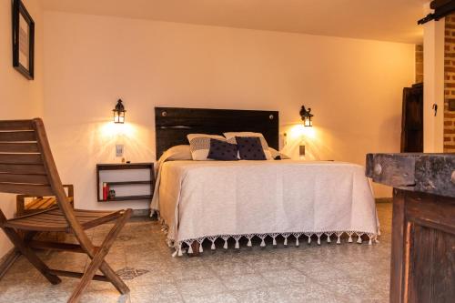 a bedroom with a large bed and a wooden chair at Casa de hospedaje -La Abadía de San Pedro in Guadalajara