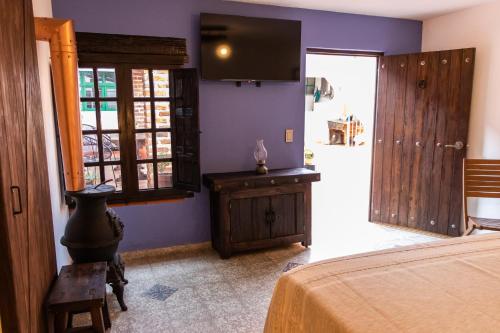 a bedroom with a bed and a tv on the wall at Casa de hospedaje -La Abadía de San Pedro in Guadalajara