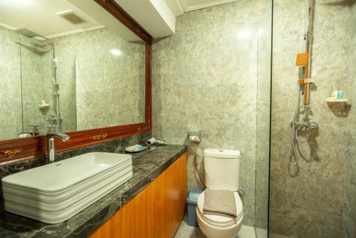 a bathroom with a toilet and a sink and a shower at The Central Lovina Hotel & Restaurant in Lovina