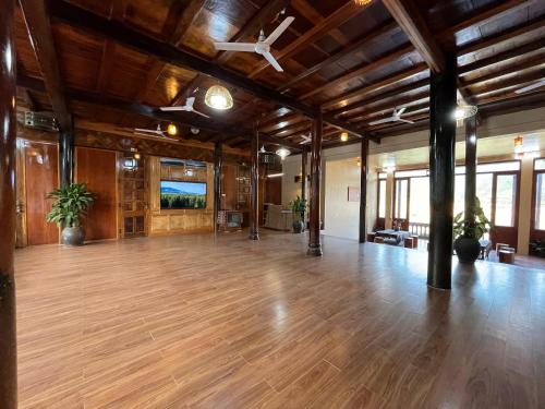a large room with wooden floors and a ceiling at Homestay Cánh Đồng Vàng in Hữu Lũng