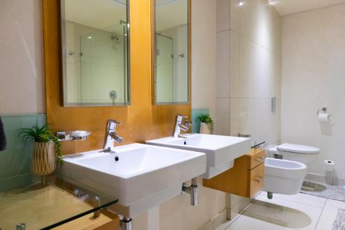 a bathroom with two sinks and a toilet at The Pearls One Bedroom Apartment in Durban