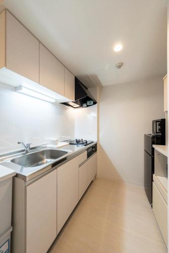 a kitchen with white cabinets and a sink at Unakite in Kita-rokujō