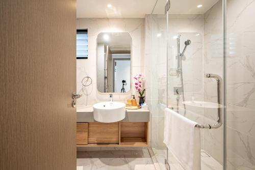 a white bathroom with a sink and a shower at Zenity Luxury Apartment in District 1 since 2024 in Ho Chi Minh City