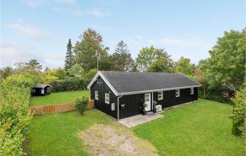 a black house with a yard with a yard at Holiday Home Strandbakken Bogø By Iv in Bogø By