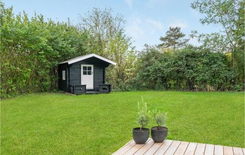 a small black and white shed in a yard at Holiday Home Strandbakken Bogø By Iv in Bogø By
