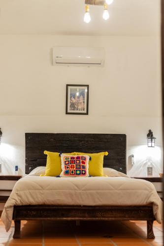 a bedroom with a large bed with yellow pillows at Casa de hospedaje -La Abadía de San Pedro in Guadalajara