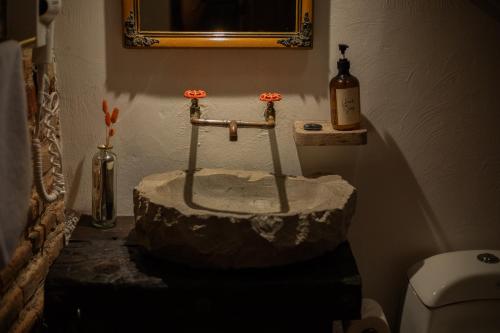 a bathroom with a rock sink in the corner of a room at Casa de hospedaje -La Abadía de San Pedro in Guadalajara