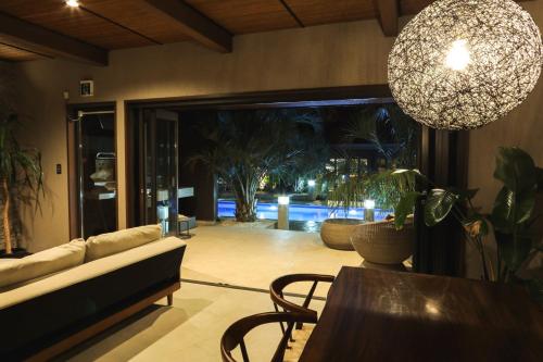 a living room with a couch and a table and a chandelier at Sunrise Villa Oarai in Natsumi