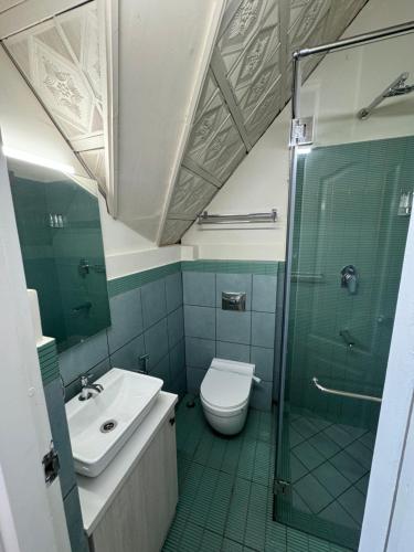 a bathroom with a shower and a toilet and a sink at River Wild holiday home in Athirappilly