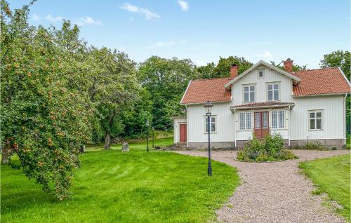 a white house with an apple tree in the yard at 4 Bedroom Stunning Home In Ödeshög in Ödeshög