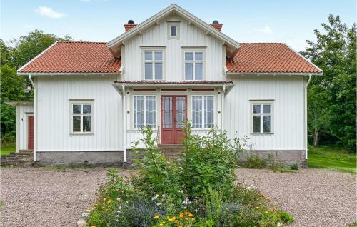 a white house with a red door at 4 Bedroom Stunning Home In Ödeshög in Ödeshög