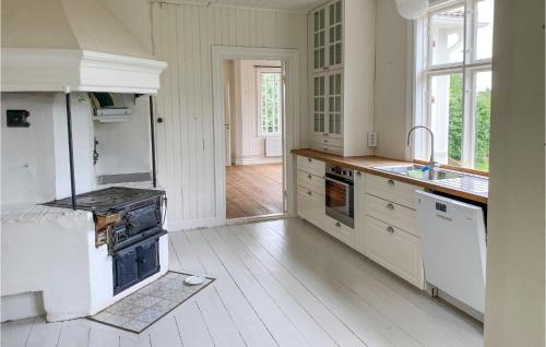 a white kitchen with a stove and a sink at 4 Bedroom Stunning Home In Ödeshög in Ödeshög