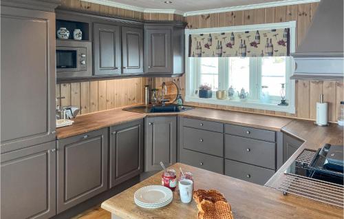 a kitchen with gray cabinets and a wooden table at Beautiful Home In Flå With Sauna in Flå