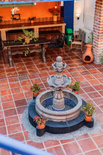 a fountain in the middle of a patio with plants at Casa de hospedaje -La Abadía de San Pedro in Guadalajara