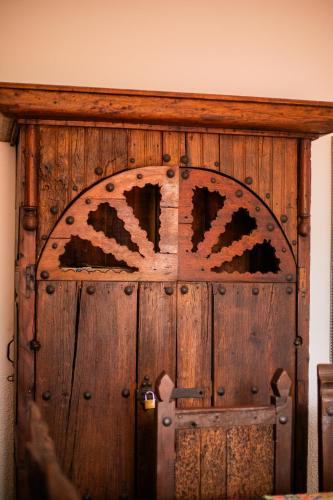 an old wooden door with a sign on it at Casa de hospedaje -La Abadía de San Pedro in Guadalajara