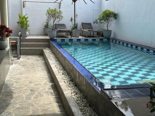 a swimming pool with a checkered tile floor and stairs at Hotel Emanuel Kabalana in Piyadigama