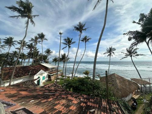 a view of the ocean and palm trees at Hotel Emanuel Kabalana in Piyadigama