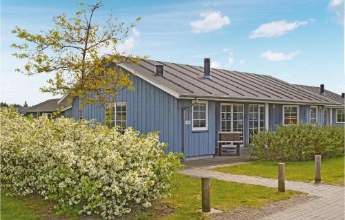 a blue house with a garden and bushes at 4 Bedroom Lovely Home In Nørre Nebel in Lønne Hede