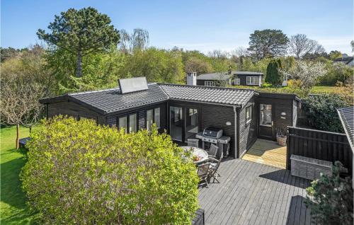 a large black cabin with a deck in a garden at Beautiful Home In Nykøbing Sj With Wifi in Nyrup