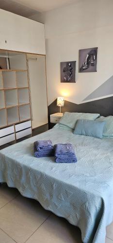 a bedroom with a bed with two blue pillows on it at Palermo Apart 3 in Buenos Aires