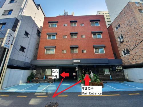 a building with a red arrow in front of it at Daejeon Guesthouse Sky Garden in Daejeon