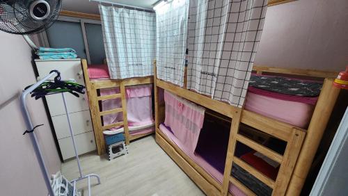 a room with two bunk beds and a refrigerator at Daejeon Guesthouse Sky Garden in Daejeon