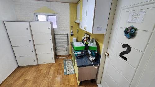 a room with a desk and a door and a hallway at Daejeon Guesthouse Sky Garden in Daejeon
