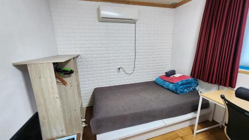 a small room with a bed and a shower at Daejeon Guesthouse Sky Garden in Daejeon
