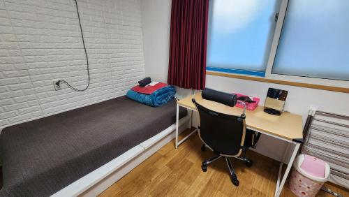 a dorm room with a bed and a desk and a desk at Daejeon Guesthouse Sky Garden in Daejeon