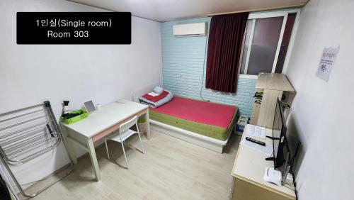 a small room with a bed and a desk at Daejeon Guesthouse Sky Garden in Daejeon
