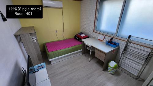 a small room with a desk and a bed at Daejeon Guesthouse Sky Garden in Daejeon