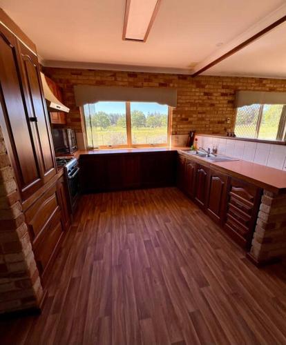 a large kitchen with wooden floors and a large window at Myra Downs in Harvey