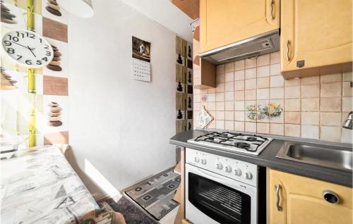 cocina con fogones y reloj en la pared en Amazing Apartment In Gdansk With Wifi, en Gdansk
