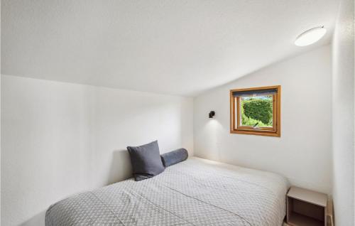 a small bedroom with a bed and a window at Cozy Home In Assens With House Sea View in Assens