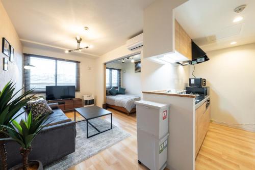 a kitchen and living room with a couch and a living room at Unison in Kita-rokujō