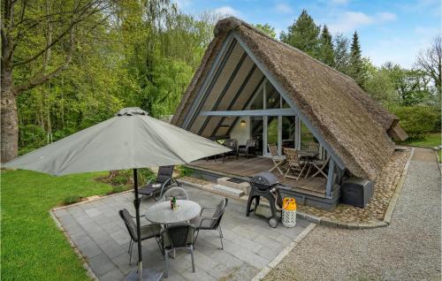 a tent with a table and chairs and an umbrella at 2 Bedroom Nice Home In Aabenraa in Loddenhøj