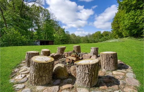 a pile of tree stump logs in a field at 2 Bedroom Nice Home In Aabenraa in Loddenhøj