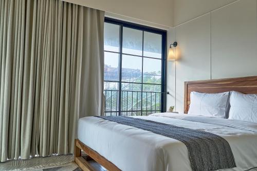 a bedroom with a bed and a large window at Rio Royale in Candolim