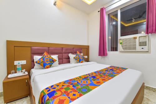 a bedroom with a large bed with a colorful blanket at FabHotel Hari Residency in Haridwār