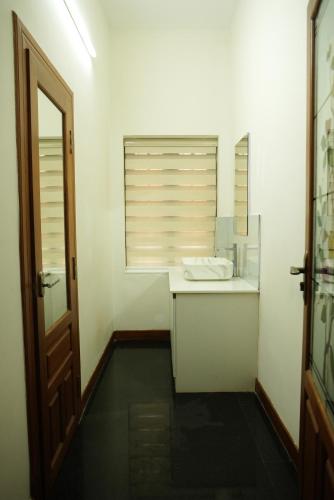 a white bathroom with a sink and a window at Puzhayoram holiday home, Aluva in Alwaye
