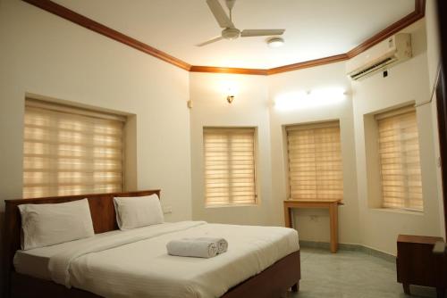 a bedroom with a bed with a pillow on it at Puzhayoram holiday home, Aluva in Alwaye
