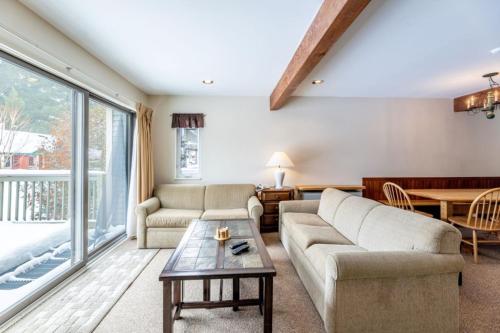 un soggiorno con un divano e un tavolo di 4BR Private Townhouse at Smugglers' Notch Resort condo a Jeffersonville